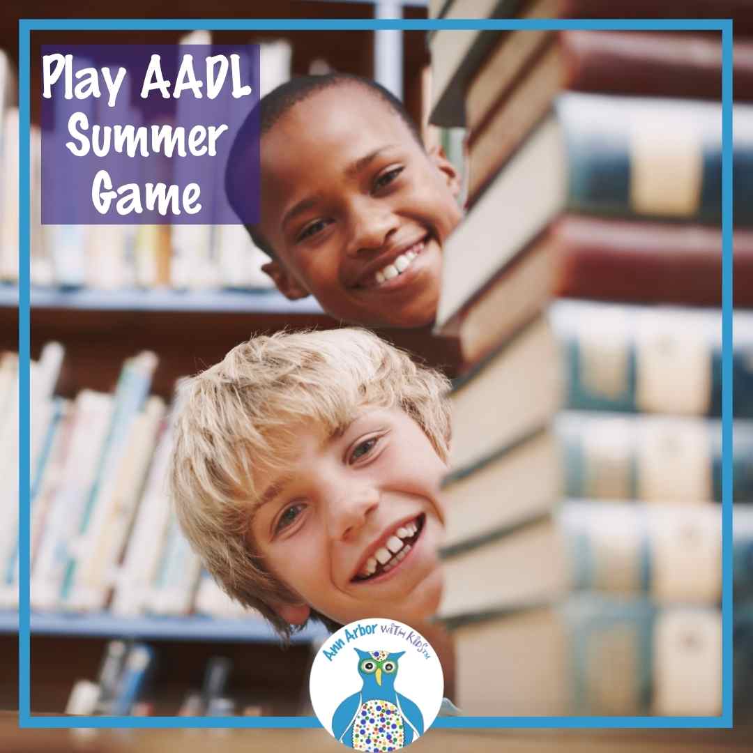 Play AADL Summer Game - two kids peek out from behind a stack of books in the library