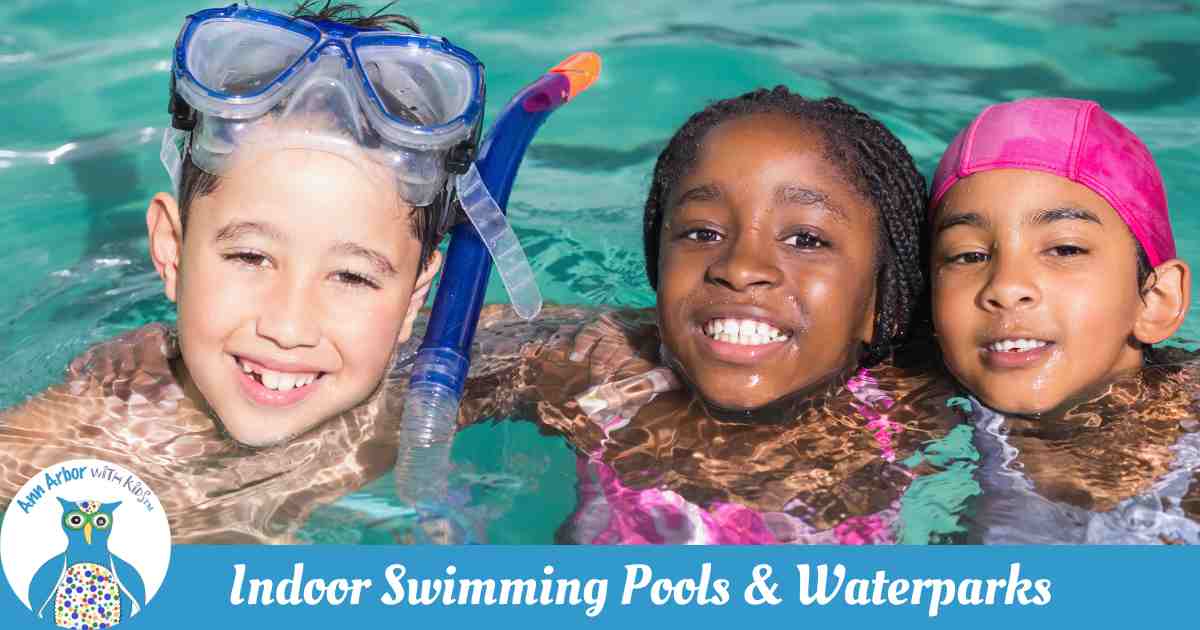 Ann Arbor Indoor Swimming Pools & Water Parks - three kids in the pool hug and look at camera. One has googles & snorkel, another wears a swim cap
