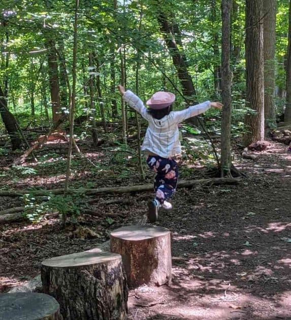 Apple Scouts Camp - Child leaping off tree stumps