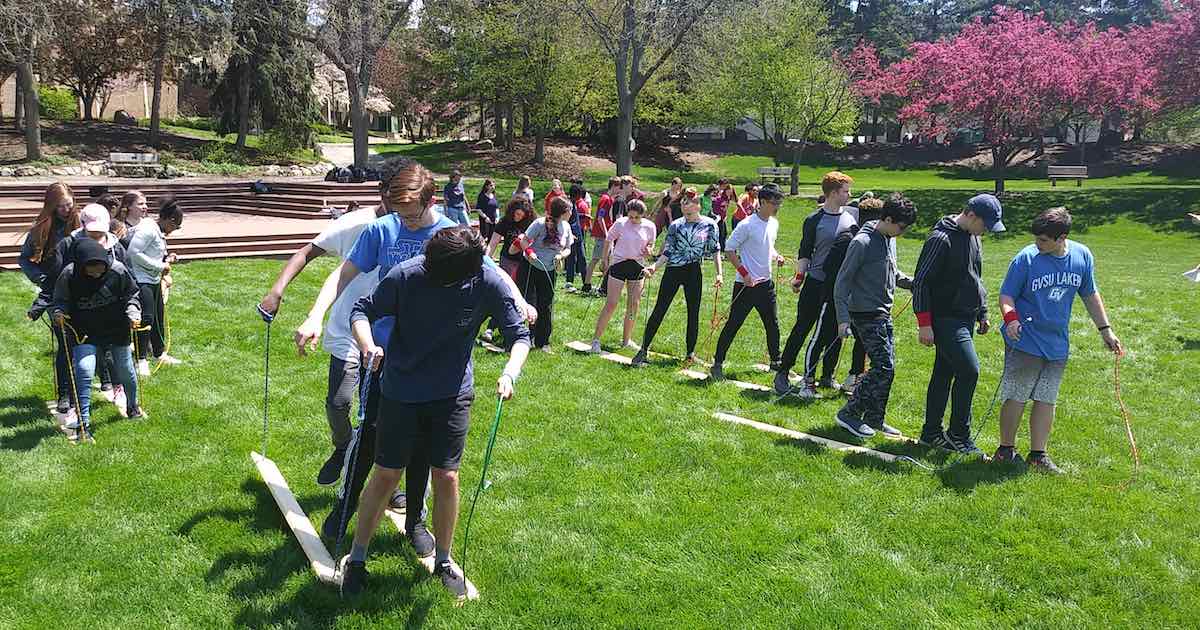 Camp Curiouser - Groups of Teens playing Cooperative Group Games - walking on planks