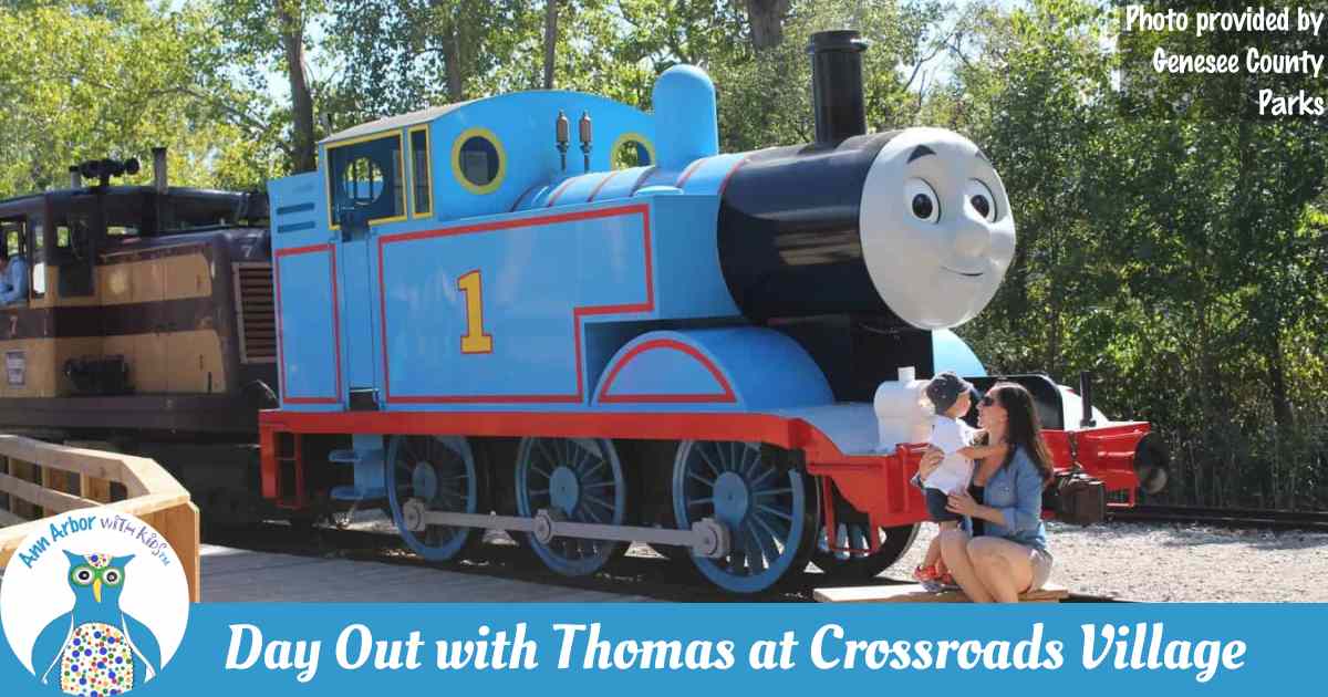 Day Out with Thomas™️ - Crossroads Village - Thomas the Tank Engine™️ on the tracks with a mother and child posing in front - Photo provided by Genesee County Parks