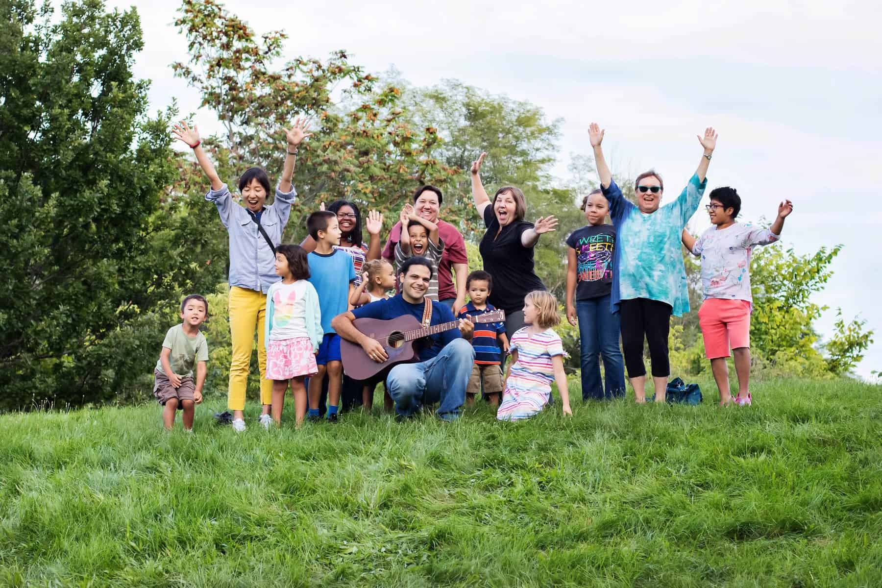 First Steps Kids Fest - Musician Joe Reilly surrounded by cheering parents and kids outdoors
