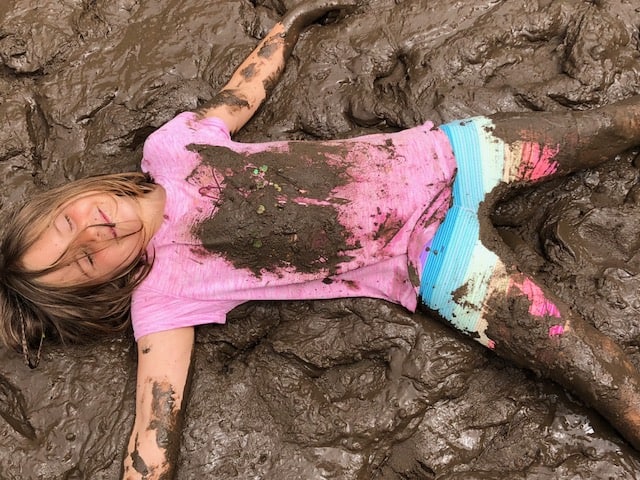 Mud Day - Girl laying in mud making a mud angel